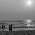 Chennai,India,Jan 21 2018: Black and white silhouette of group of friends and family having peaceful and leisure time at Marine beach near the shore.